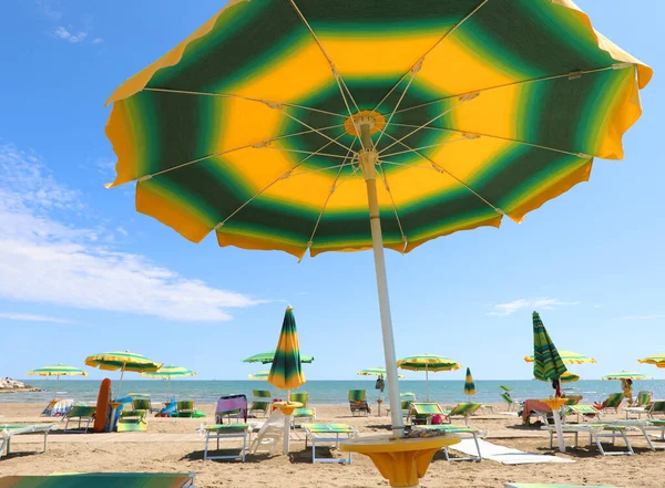 Ηλιόλουστη Παραλία Και Μια Μεγάλη Πράσινη Και Κίτρινη Ομπρέλα Την — Φωτογραφία Αρχείου