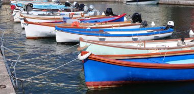 Marina 'da insansız demirlemiş bir sürü küçük tahta tekne var.