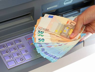 many banknotes taken from a bank ATM machine in a European city clipart