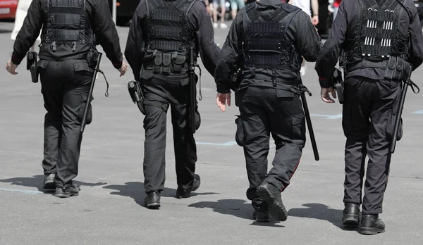 Pattuglia Quattro Poliziotti Con Manganelli Pistole Che Controllano Città — Foto Stock