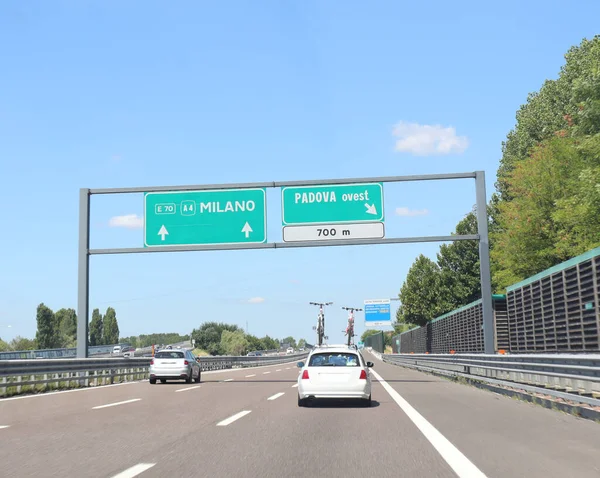 宽阔的公路标志 上面有意大利米兰市的名称和通往帕多瓦奥斯特的出口公路 — 图库照片