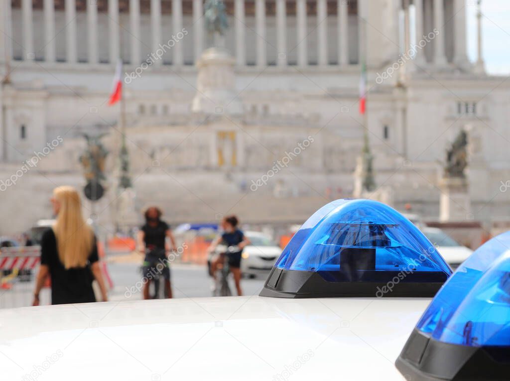Blue sirens of police  car and the Monument called Altare della Patria in background in Rome
