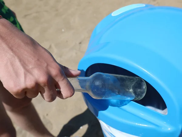 男孩的手把旧玻璃瓶扔进垃圾箱 以便在海滩上分开收集废物 — 图库照片