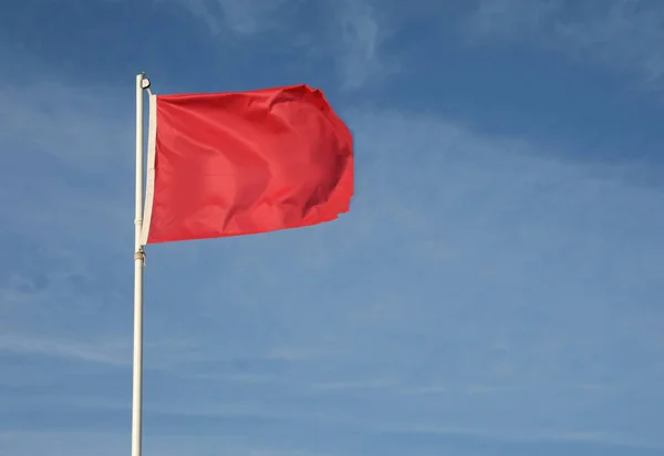 蓝色天空上的大红旗象征着危险和危险 — 图库照片