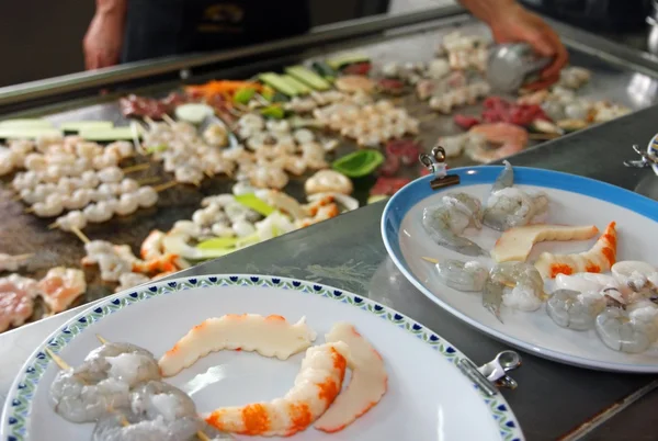 Cozinheiro chinês enquanto assa peixe e carne em prato — Fotografia de Stock