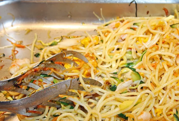 Spaghetti topped with vegetables and meat — Stock Photo, Image