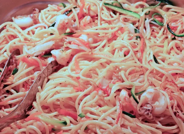 Spaghetti topped with vegetables and meat served at the restaura — Stock Photo, Image