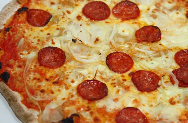 Vedugnsbakad pizza på en vedeldad ugn med lök och pepperoni — Stockfoto