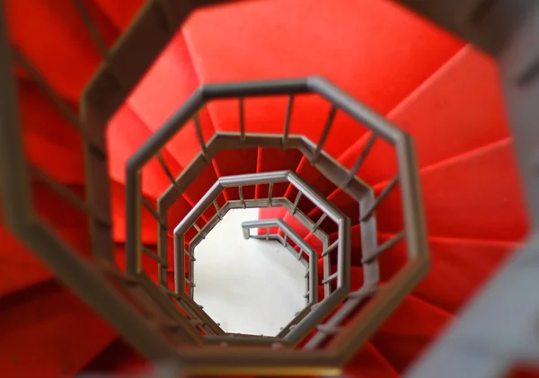 Schwindelerregend steile Wendeltreppe mit rotem Teppich — Stockfoto