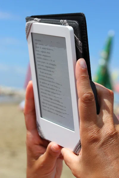 Γυναίκα να διαβάσετε ένα e-Book στην παραλία στις ξαπλώστρες — Φωτογραφία Αρχείου