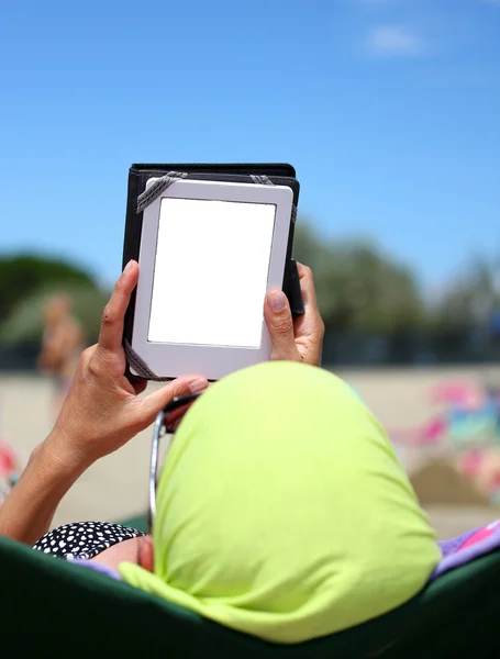 Frau las ein eBook am Strand — Stockfoto