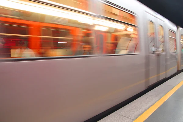 Pociąg, który przemieszcza się szybko w stacji metra na torze — Zdjęcie stockowe