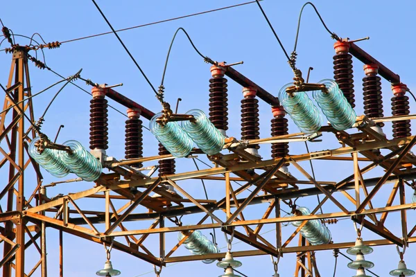 Grandes aislantes en una central eléctrica con pilones altos de alta volta — Foto de Stock