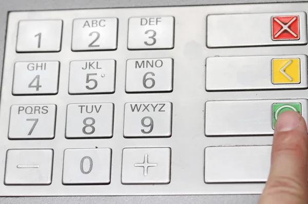 Index qui confirme le code secret dans le clavier d'un distributeur automatique — Photo
