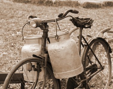 Rusty bike of a milkman of the last century with two bins clipart