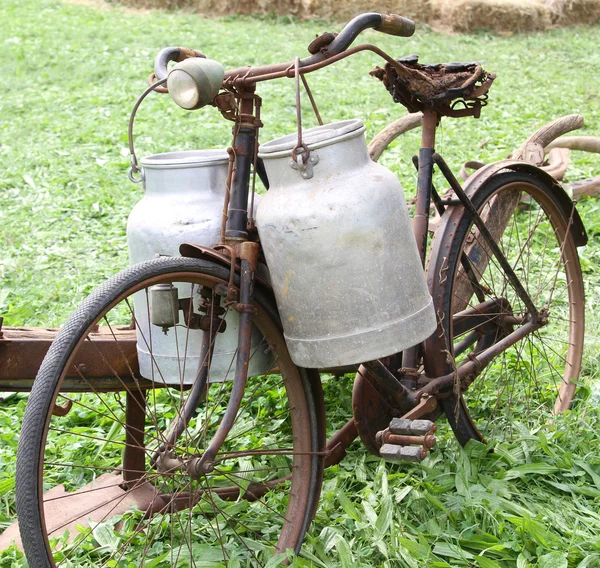 Vieja bicicleta oxidada del lechero con dos latas de leche viejas y rotas —  Fotos de Stock