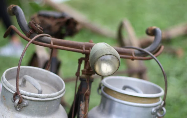 Old bikes milkman with milk cans and bicycle taillight — Stock Photo, Image