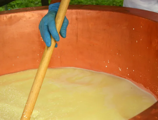 Melkboer bak ricotta kaas in grote koperen pot in zuivel — Stockfoto