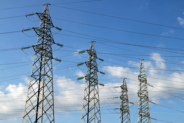 Τέσσερις πυλώνες υψηλής τάσης ηλεκτρικών καλωδίων σταθμών παραγωγής ηλεκτρικού ρεύματος — Φωτογραφία Αρχείου