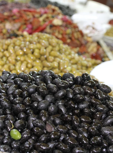Zielone oliwki różnego rodzaju na sprzedaż na rynku z południowej — Zdjęcie stockowe