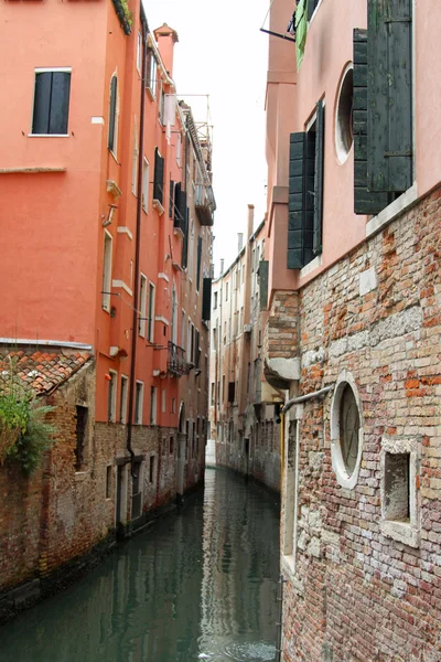 Stretto canale navigabile tra le alte case di Venezia in Ital — Foto Stock