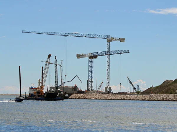 GRANES imposantes sur le chantier de construction au bord de la mer — Photo