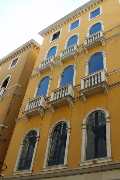 Facciata gialla con finestra blu di un palazzo veneziano prominente in — Foto Stock