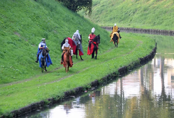 Mittelalterliche Ritter in mittelalterlichen Gewändern fahren entlang des Flusses — Stockfoto