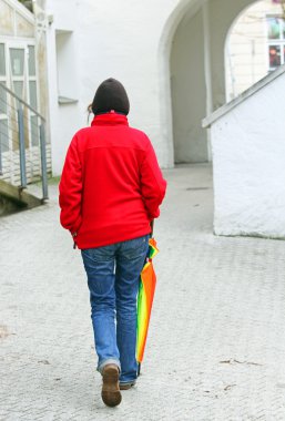 Kırmızı kazağı ile Mavi Jeans kadın şemsiye ile yürüyor