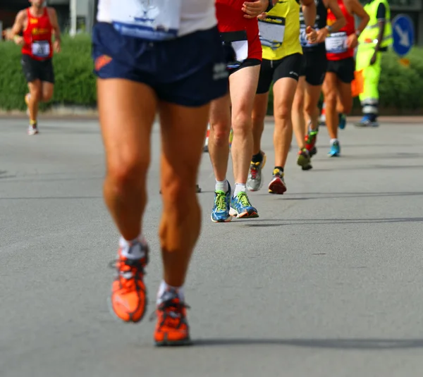 Pernas de atletas envolvidos em longa maratona internacional — Fotografia de Stock