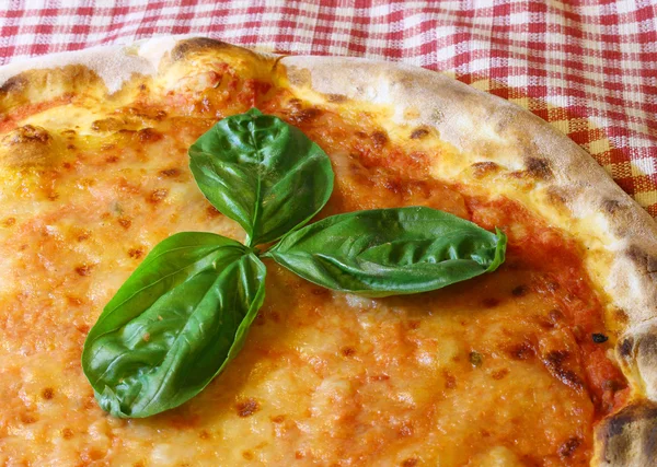 Tre foglie di basilico sopra la deliziosa pizza italiana in pizzeri — Foto Stock