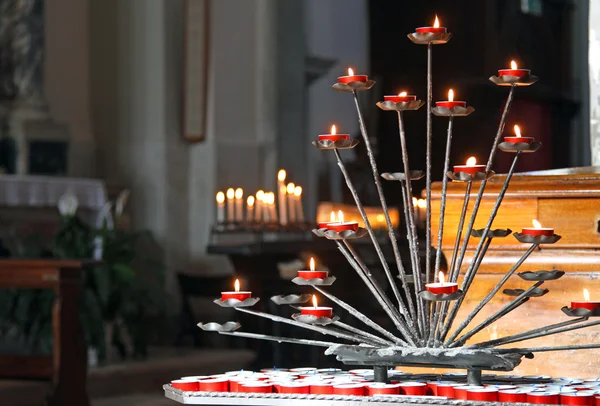 Church with candelabra and lit candles during the prayers of the — Stock Photo, Image