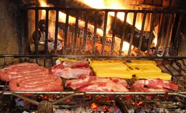 Rund- en varkensvlees op de grill in de gloeiende sintels van de fireplac — Stockfoto
