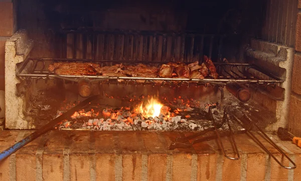 Smoky fireplace with lots of grilled meat in the restaurant — стоковое фото