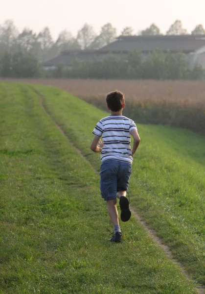 Child runs along a country road — Stock Photo, Image