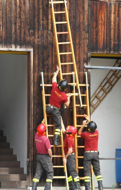 firefighters during the fire drill mount fast wooden ladder clipart