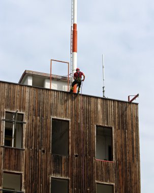 fireman climbing expert during the ascent abseiling from a build clipart