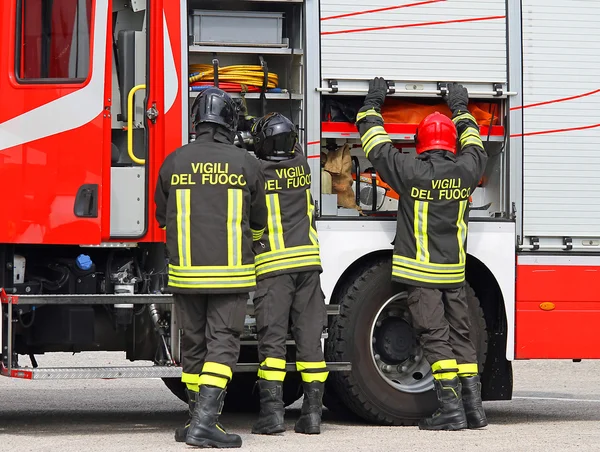 Firefighters working near the fire truck when handling an emerge — Stock Photo, Image