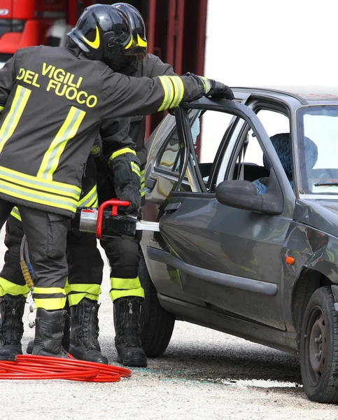 Feuerwehrleute öffnen die Autotür mit einer leistungsstarken Schere — Stockfoto