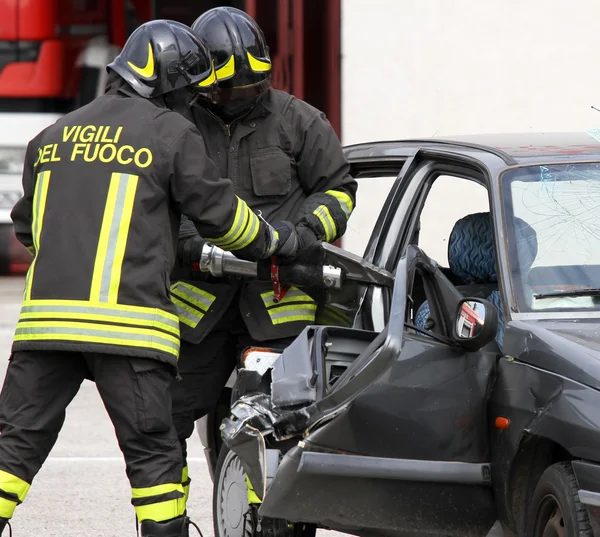 Los bomberos abren el coche con unas poderosas tijeras neumáticas —  Fotos de Stock