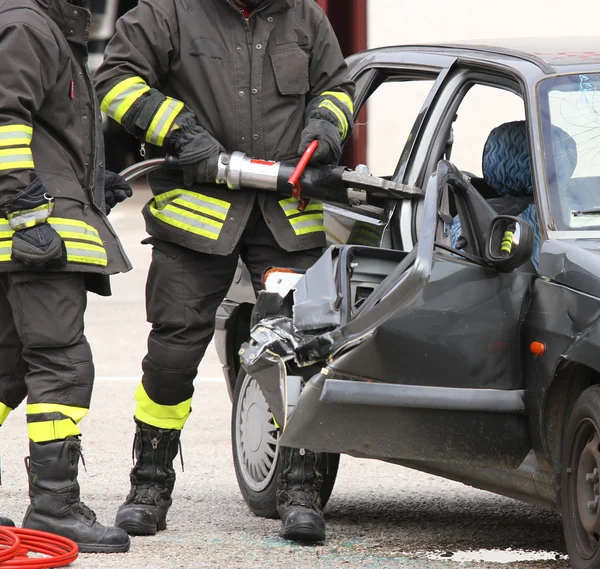 Пожарные открывают машину пневматическими ножницами — стоковое фото