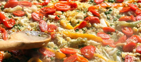 Cooking Spanish paella with wooden spoon — Stock Photo, Image