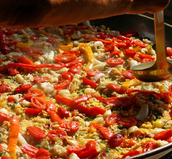 Španělská paella vaření s lžící šéfkuchaře — Stock fotografie