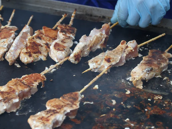 Skewers of meat cooked on a griddle — Stock Photo, Image