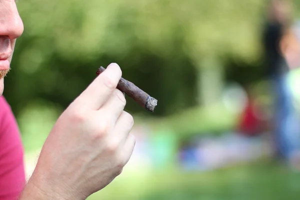 Joven fumador con cigarro fino en la mano —  Fotos de Stock