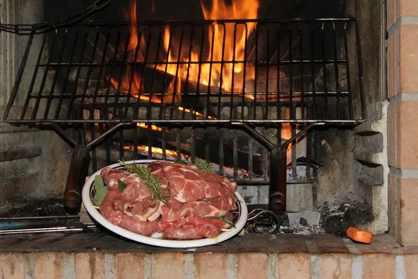 暖炉の燃える残り火で焼き豚肉と一緒に家 — ストック写真