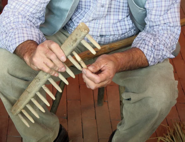 Artigiano del legno mentre ripara un vecchio rastrello di legno — Foto Stock