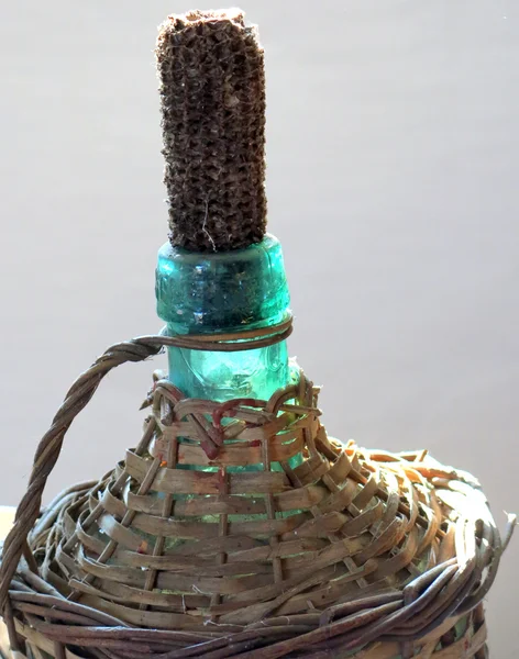 Стеклянная бутылка антикварной плетеной одежды, чтобы держать масло — стоковое фото