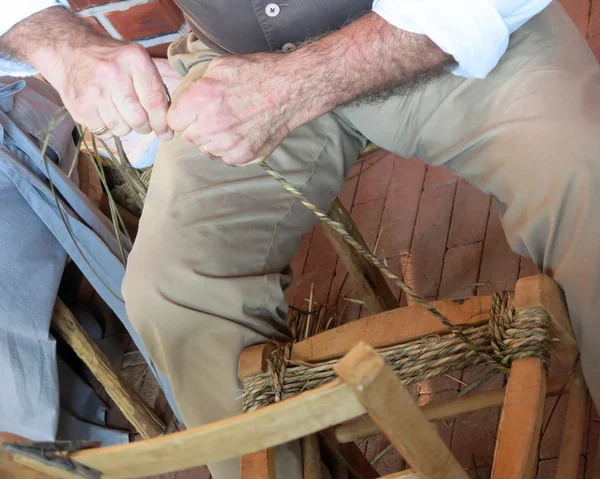 Älterer Mann geschickte Erdbeerlinie aus altem Holz und Rattan Chai — Stockfoto