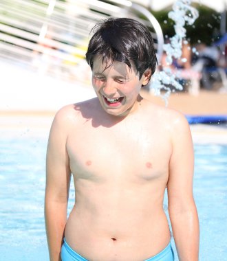 genç çocuk yaz aylarında havuz suyu içinde eğleniyor